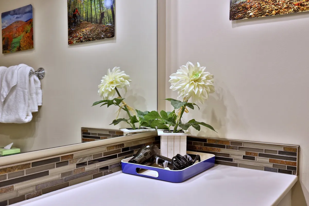 An interior shot featuring tasteful decor with white flowers, a decorative tray, and a textured backsplash reflected in a mirror. The setting feels serene, inviting, and cozy—an ideal retreat after a day spent outdoors.